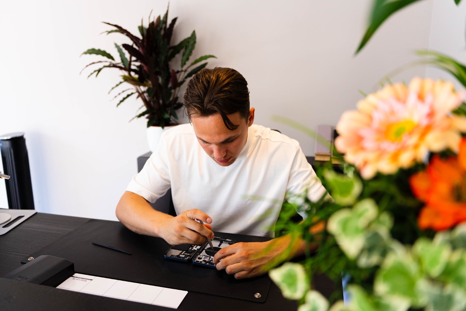 Jan Martens voert een telefoonreparatie uit bij BelJan in Castricum